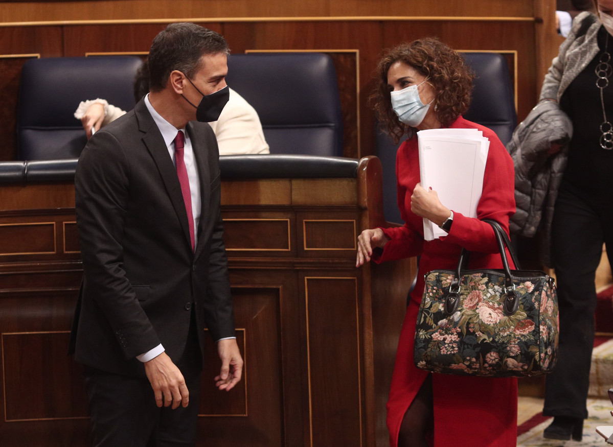 El presidente del Gobierno, Pedro Sánchez, conversa con la ministra de portavoz y de Hacienda, María Jesús Montero (d), al término de la primera parte del pleno de Debate de totalidad del Proyecto