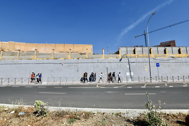 Diversos migrants procedents del Marroc fan cua en les portes de la frontera de Ceuta on agents de la Policia Nacional reparteixen cites per a sol·licitud d'asil, a 2 de juny de 2021, a Ceuta (Espany