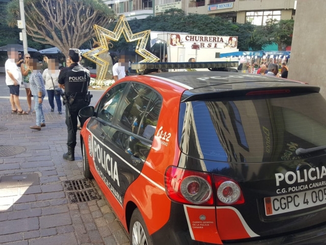 EuropaPress 2496287 agente policia canaria junto coche patrulla