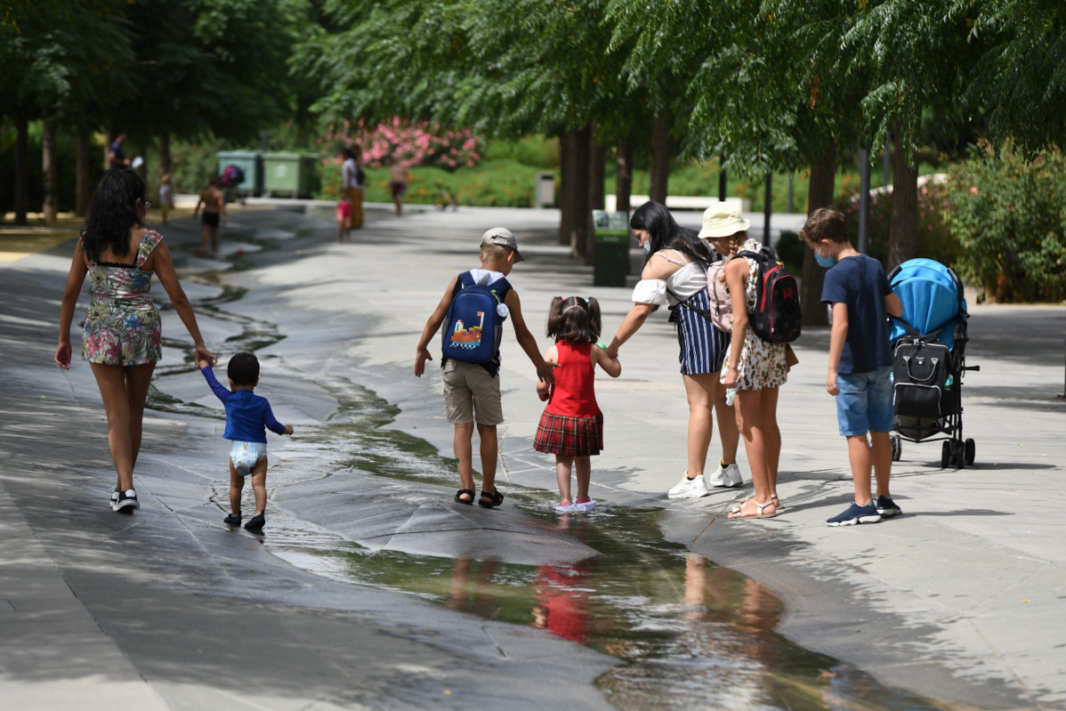 Varios niños pasan por un arroyo de agua en el Parc Central, a 12 de agosto de 2021, en Valencia, Comunidad Valenciana (España). Como consecuencia de la ola de calor que comenzó ayer en toda Españ
