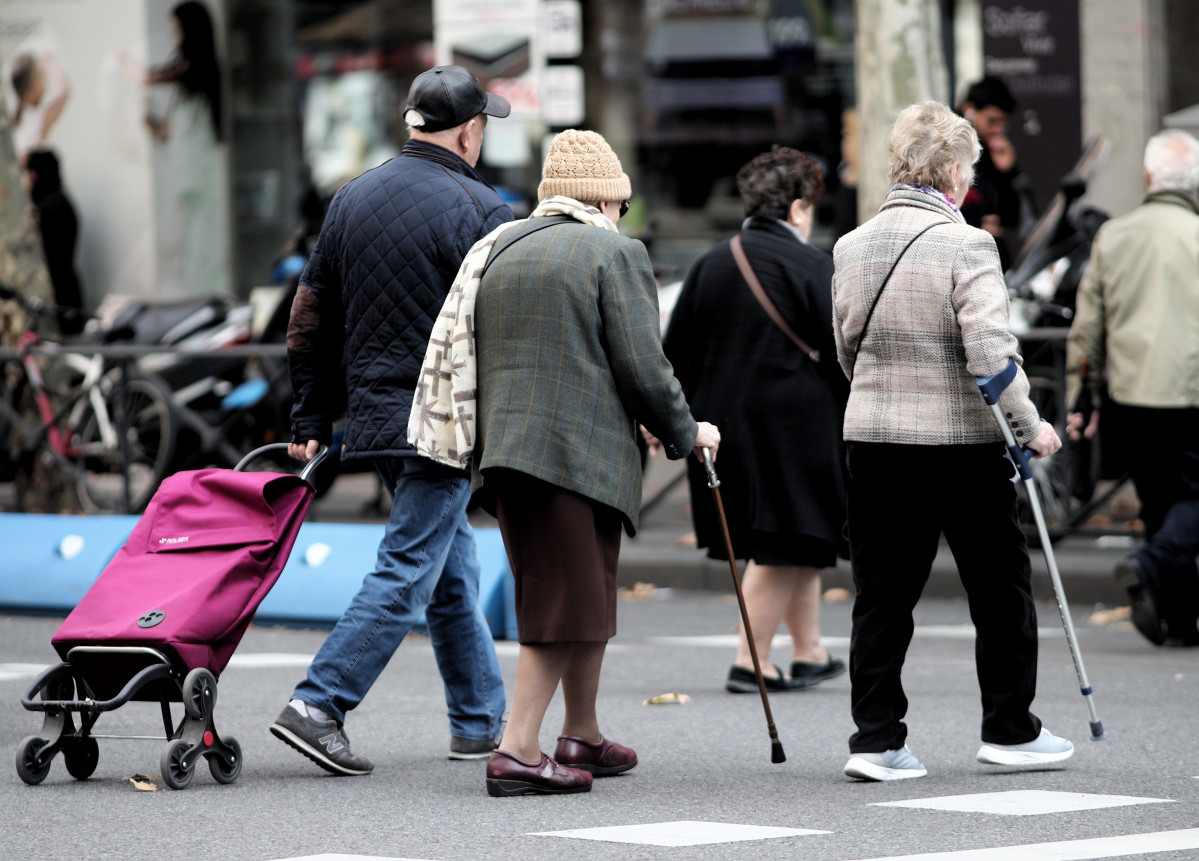 Archivo - Varias personas de la tercera edad cruzan un paso para peatones con ropa de abrigo, en Madrid (España), a 7 de noviembre de 2019.