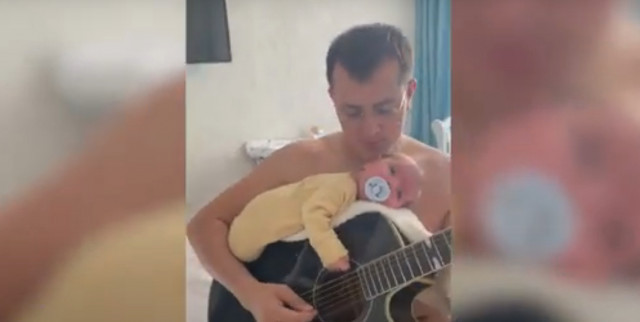 Aconsegueix dormir el seu bebè tocant la guitarra amb el nen sobre l'instrument