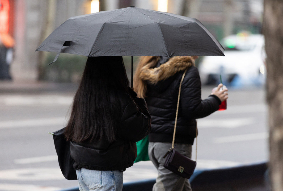 Archivo - Personas con paraguas bajo la lluvia durante la llegada de la borrasca ‘Garoé’, a 20 de enero de 2025, en Madrid (España). La AEMET avisa de la llegada de 'Garoé', séptima borrasca c