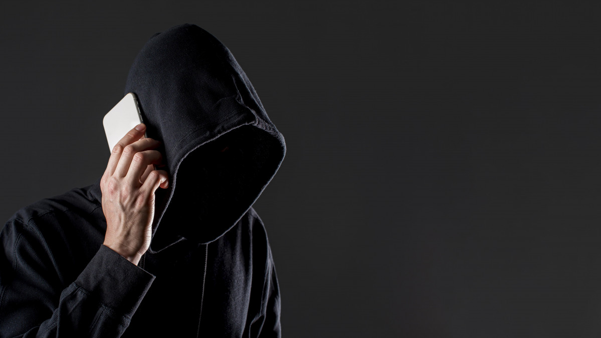 Side view male hacker talking smartphone with copy space