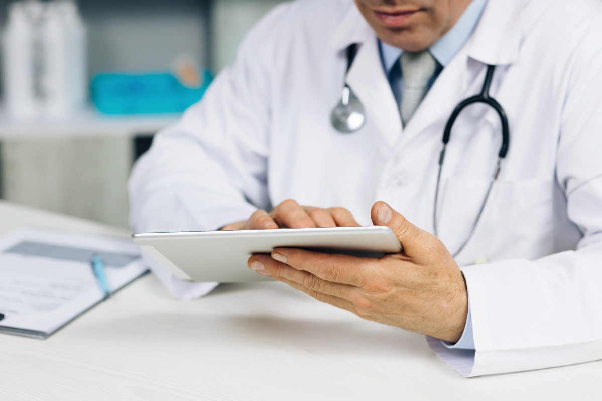 Primer pla de mans d'un mu00e9dic utilitzant una tauleta Close up of a doctor's hands using a tablet
