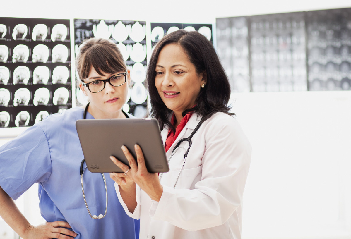 Dos trabajadoras sanitarias revisnado una radiografia en una tablet   Two healthcare workers reviewing an x ray on a tablet