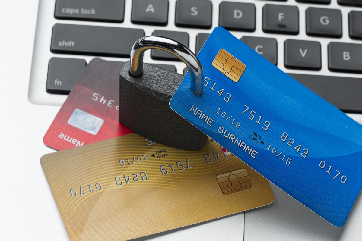 Alto angulo de bloqueo con tarjetas de credito en la parte superior de la computadora portatil