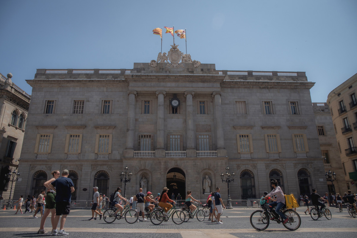 Archivo - Varias personas caminan delante del edificio del Ayuntamiento de Barcelona.
