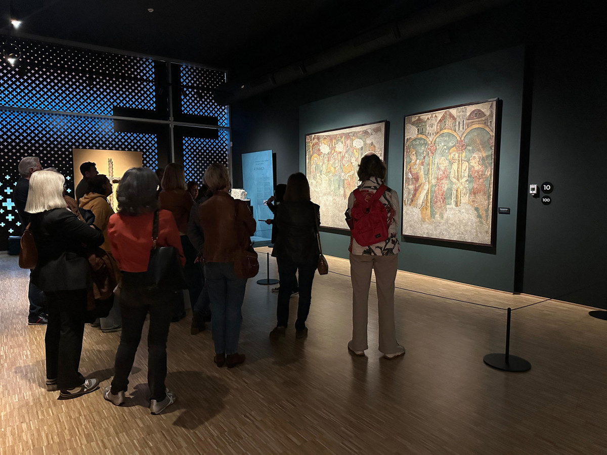 Uns visitants contemplant les pintures murals de Sant Esteve