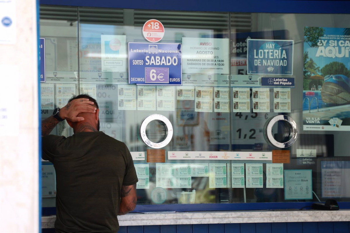 Archivo - Una persona se dispone a adquierir un boleto en una Administración de Loterias/Archivo