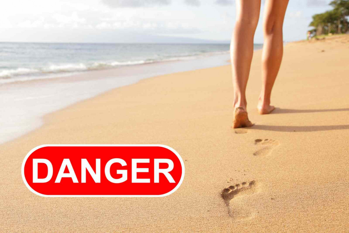 Una mujer camina por la playa; peligro   CANVA