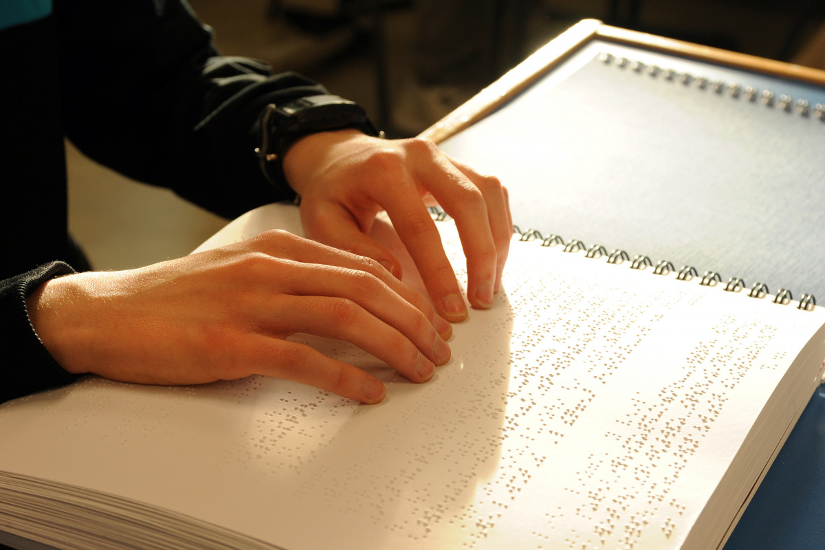 Mans llegint braille