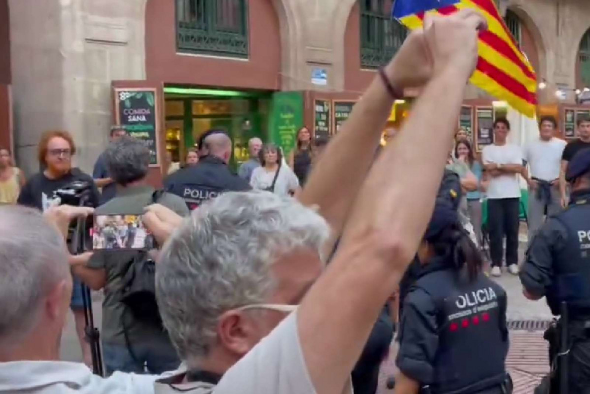 Periodistas de TV3 siendo escoltado por los Mossos en el Fossar de les Moreres   X
