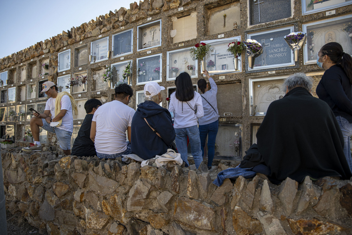 Archivo - Una mujer limpia un nicho en el cementerio de Montjuïc con motivo del Día de Todos los Santos
