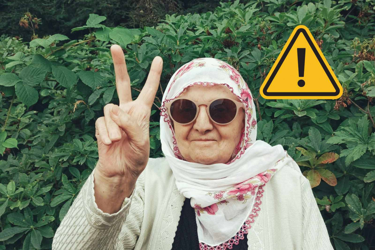 Una anciana haciendo la señal de la victroria   CANVA