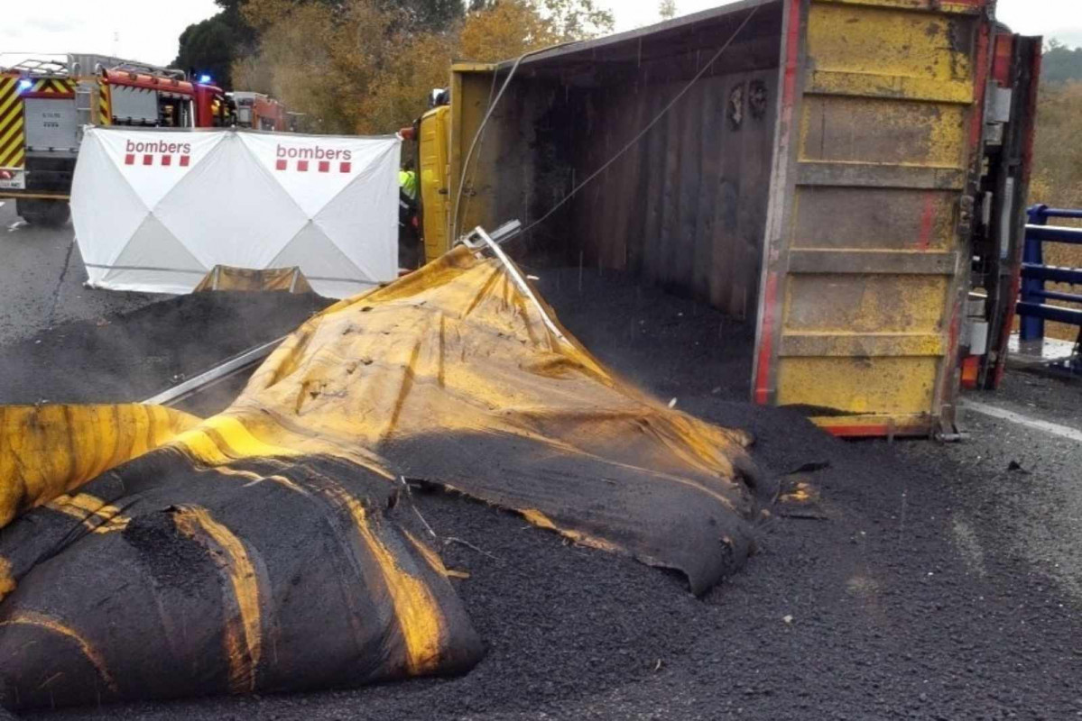 Camión que ha volcado en la AP 7 y ha perdido su carga de alquitrán   BOMBERS