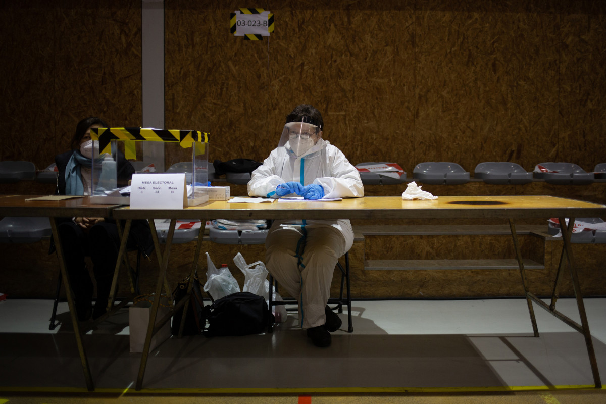 Archivo - Una mujer con un EPI en una mesa electoral del Polideportivo Tres Xemeneies en Barcelona