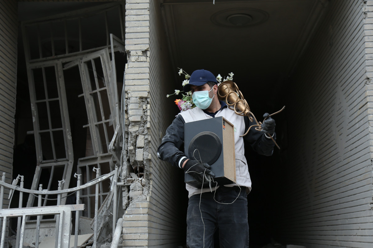 EuropaPress 7367536 beijing march 15 2026    man carries belongings searched from destroyed