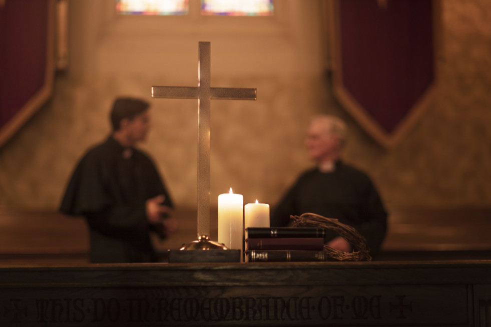 Priests praying together church