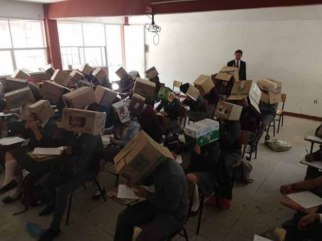 Professors posa caixes en els caps dels seus alumnes
