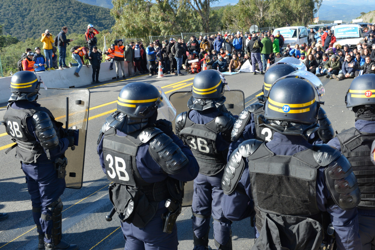 Agents de policu00eda davant de la multitud que ha tallat la carretera de l'AP 7 a la Jonquera (Girona)