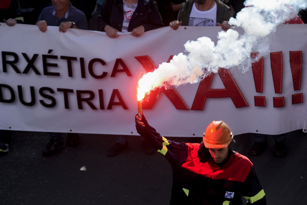 Un participant en la manifestaciu00f3n dels treballadors de la multinacional Alcoa a A Coruu00f1a, Galícia, amb una bengala a la mà