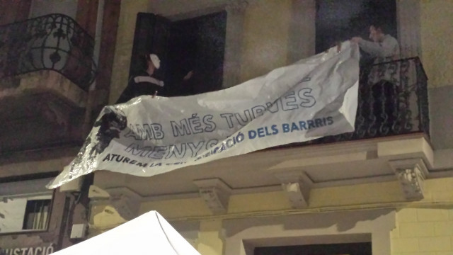 Los activistas colocan una pancarta la noche de este sábado en un balcón del edificio tras ocuparlo.