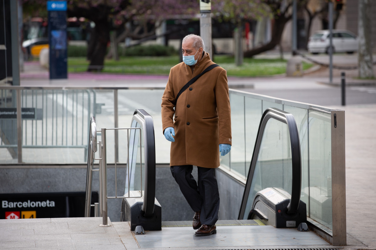 Un home Protegit amb una màscara i GUANTS de làtex SURT de el maître durante el Segon dia feiner de l'Estat d'alarma paper coronavirus, a Barcelona / Catalunya (Espanya), a 17 de març de 2020.
