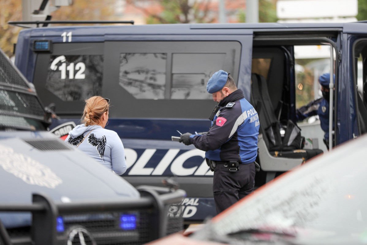 Un agent de la Policia Municipal multa a una dona per un viatge no justificat en un control policial a la Glorieta d'el Marquès de Vadillo durant el sisè dia de confinament per coronavirus en