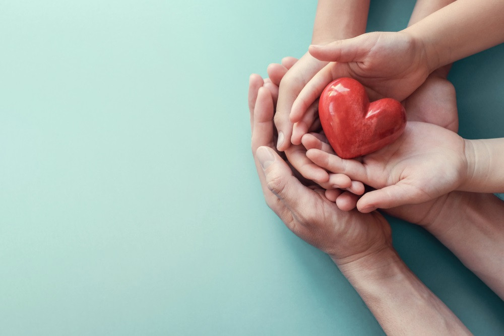 Solidaritat, amor. Mans sostenint un cor.