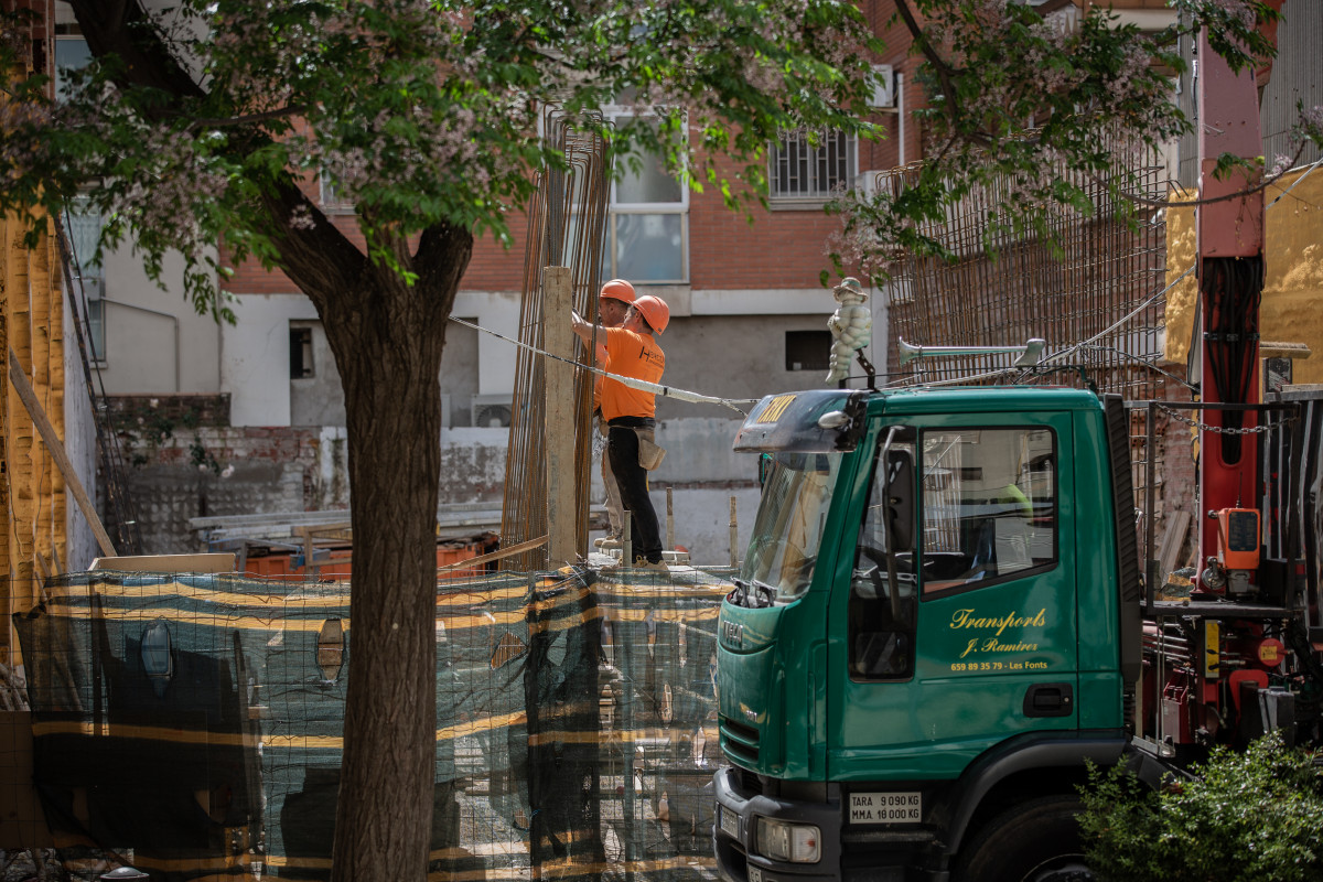 Dos operaris treballen en l'obra d'un edifici durant el dia 45 de l'estat d'alarma decretat pel Govern per la pandèmia de l'Covid-19, a Barcelona / Catalunya (Espanya) a 28 d'abril de 2020.