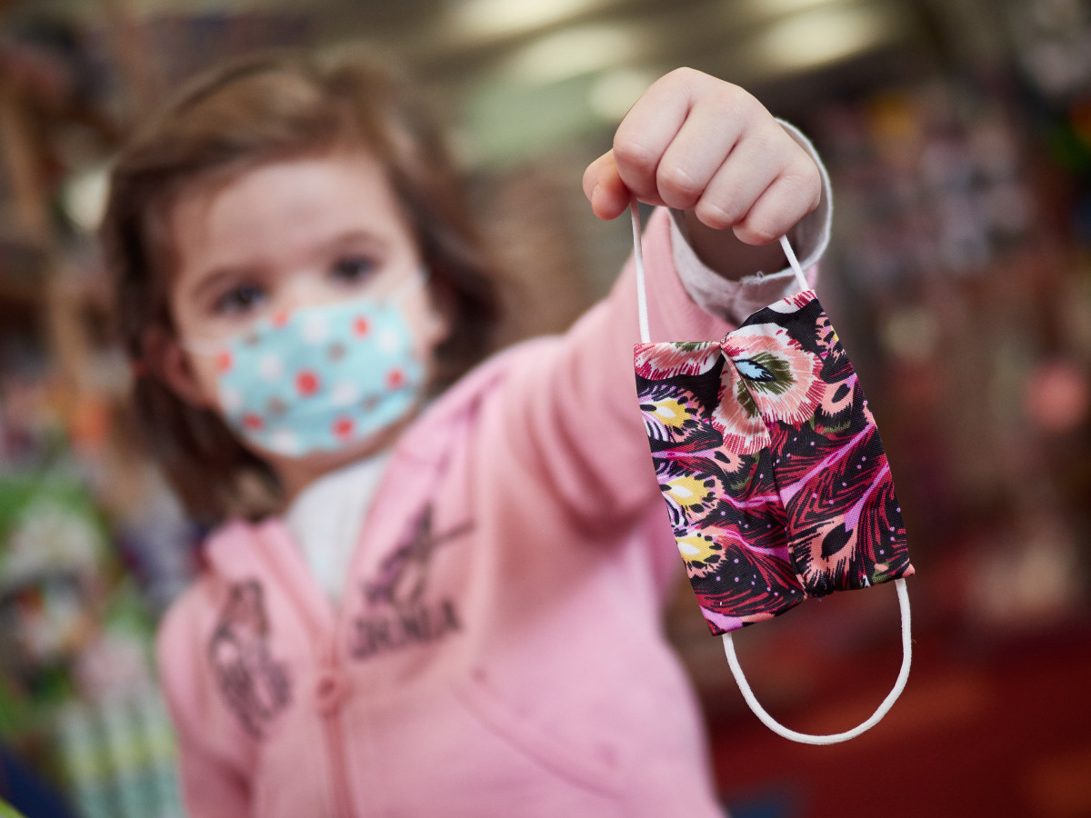 Una nena mostra una màscara infantil mentre surt al carrer a Pamplona a finals d'abril.