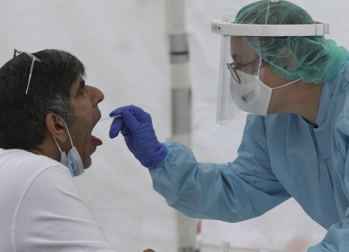Una sanitària li realitza un frotis bucal a un veí d'Ordizia en una de les carpes instal·lades al parc Barrena per l'Ajuntament d'Ordizia per realitzar test davant el possible brot de COVID-19 detectat a la localitat guipuscoana, a Ordizia, Gui