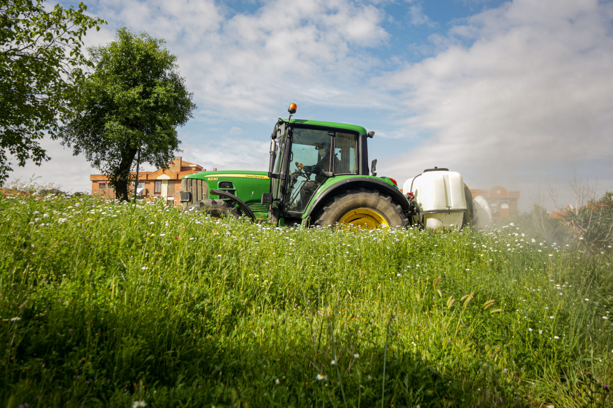 Un agricultor muntat en el seu tractor