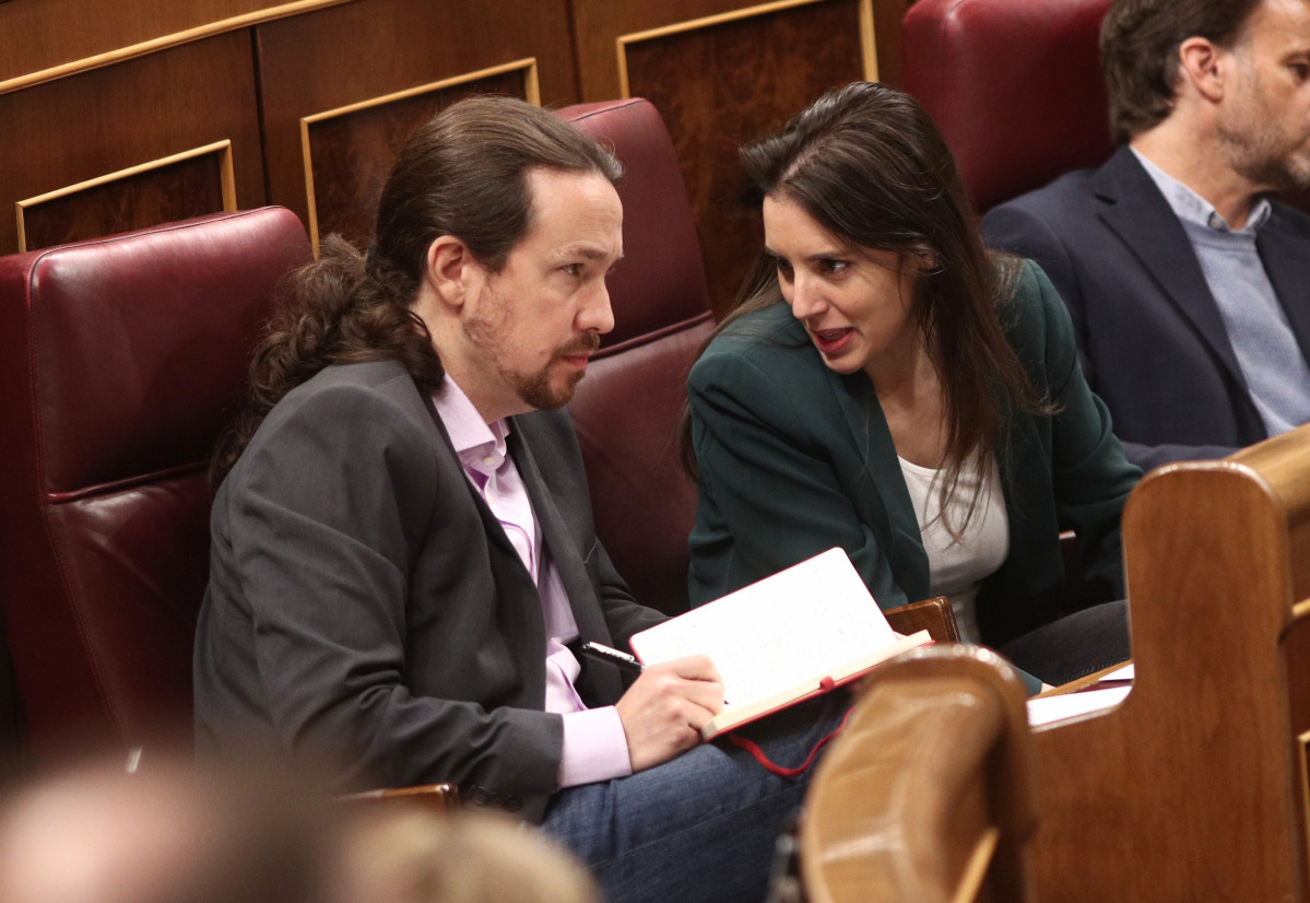 El secretari general de Podem, Pablo Iglesias, i la portaveu parlamentària d'Unides Podem, Irene Montero, parlen en els seus escons al Congrés dels Diputats durant la primera sessió del de