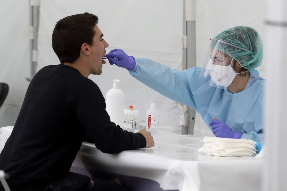 Una sanitària li realitza un frotis bucal a un veí d'Ordizia en una de les carpes instal·lades al parc Barrena per l'Ajuntament d'Ordizia per realitzar test davant el possible brot de COVID-19 detectat a la localitat guipuscoana