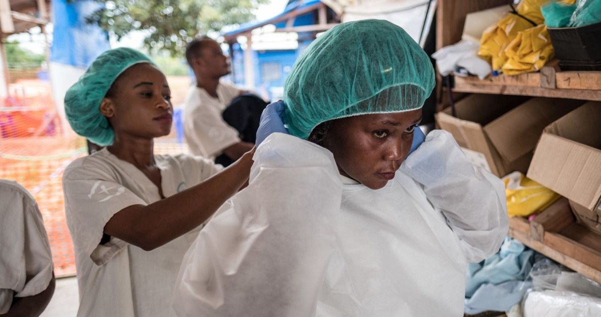 Dues dones es vesteixen amb equips de protecció durant el brot de ebola a R.D. de Congo
