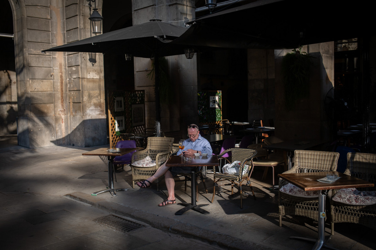 Un home consulta el seu telèfon mòbil a la terrassa d'un bar a Barcelona, Catalunya (Espanya) a 14 d'octubre de 2020. La Generalitat ha anunciat avui en roda de premsa les noves mesures que entraran en vigor la mitjanit de dijous 15 d'octubre per 1