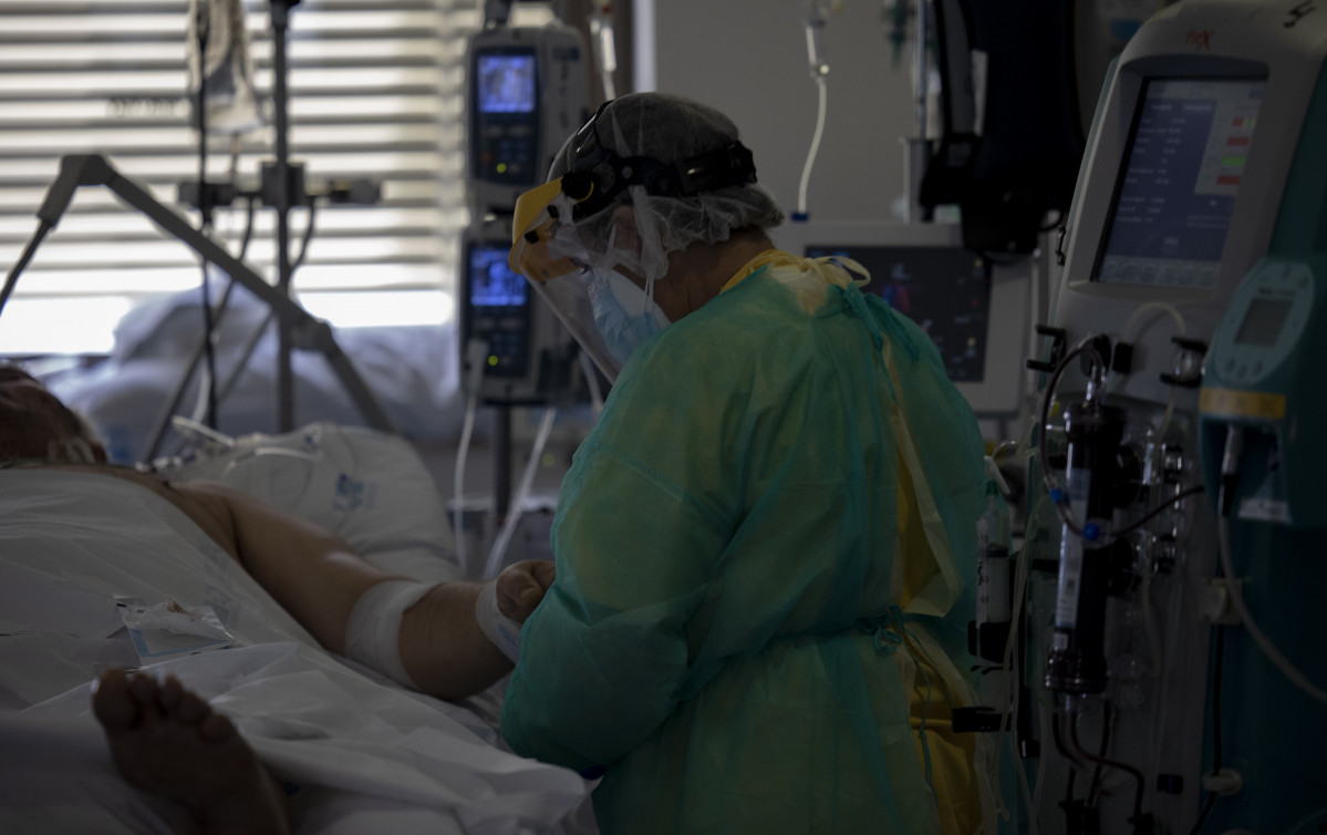 Un sanitari atén un pacient a la Unitat de Cures Intensives (UCI) dedicada a malalts de coronavirus de l'Hospital Universitari Ramón i Cajal