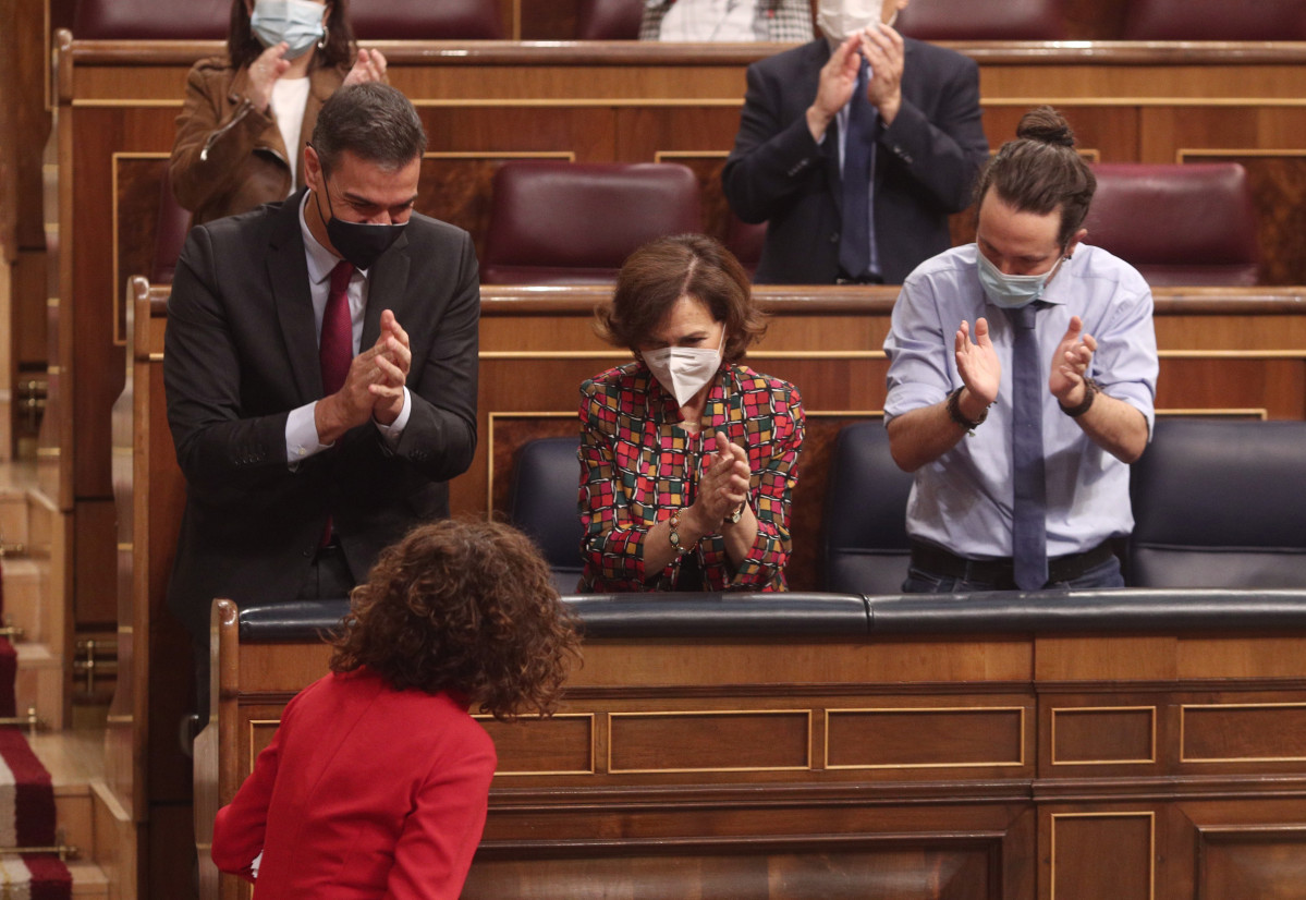 (I-D) El president de Govern, Pedro Sánchez; la vicepresidenta primera, Carmen Calvo, i el vicepresident segon, Pablo Iglesias, aplaudeixen la ministra de portaveu i d'Hisenda, María Jesús Montero, després de la seva intervenció en el ple