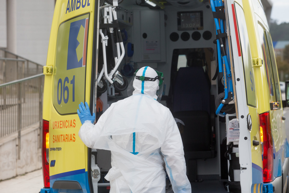 Un treballador sanitari totalment protegit tanca la porta d'una ambulància després de recollir a un ancià de la residència d'avis de Sant Cibrao on s'ha originat un brot de Covid-19, a Sant Cibrao, Lugo.
