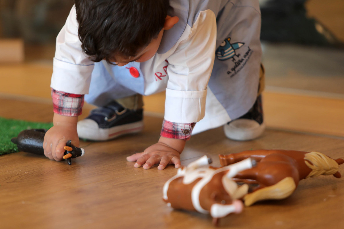 Un nen juga en una escola infantil