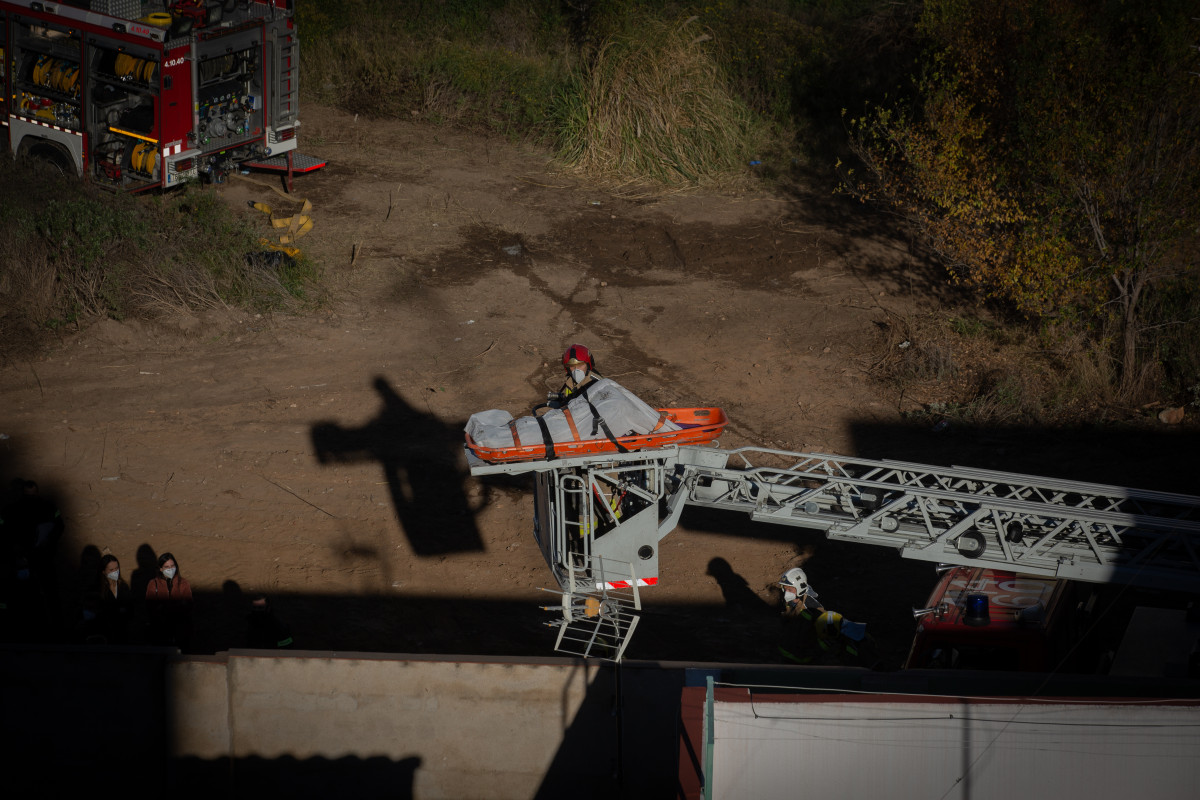 Bombers retiren el cadàver d'una de les persones mortes en l'incendi d'ahir a la nau okupada del barri de Gorg, a Badalona, Barcelona, Catalunya (Espanya), a 10 de desembre de 2020.