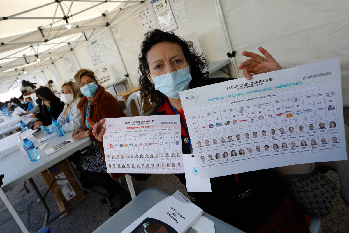 Una dona procedent de l'Equador posa amb tots els candidats a la presidència de la República de l'Equador, en una de les 64 meses electorals repartides per diverses poblacions de la Regió de Múrcia
