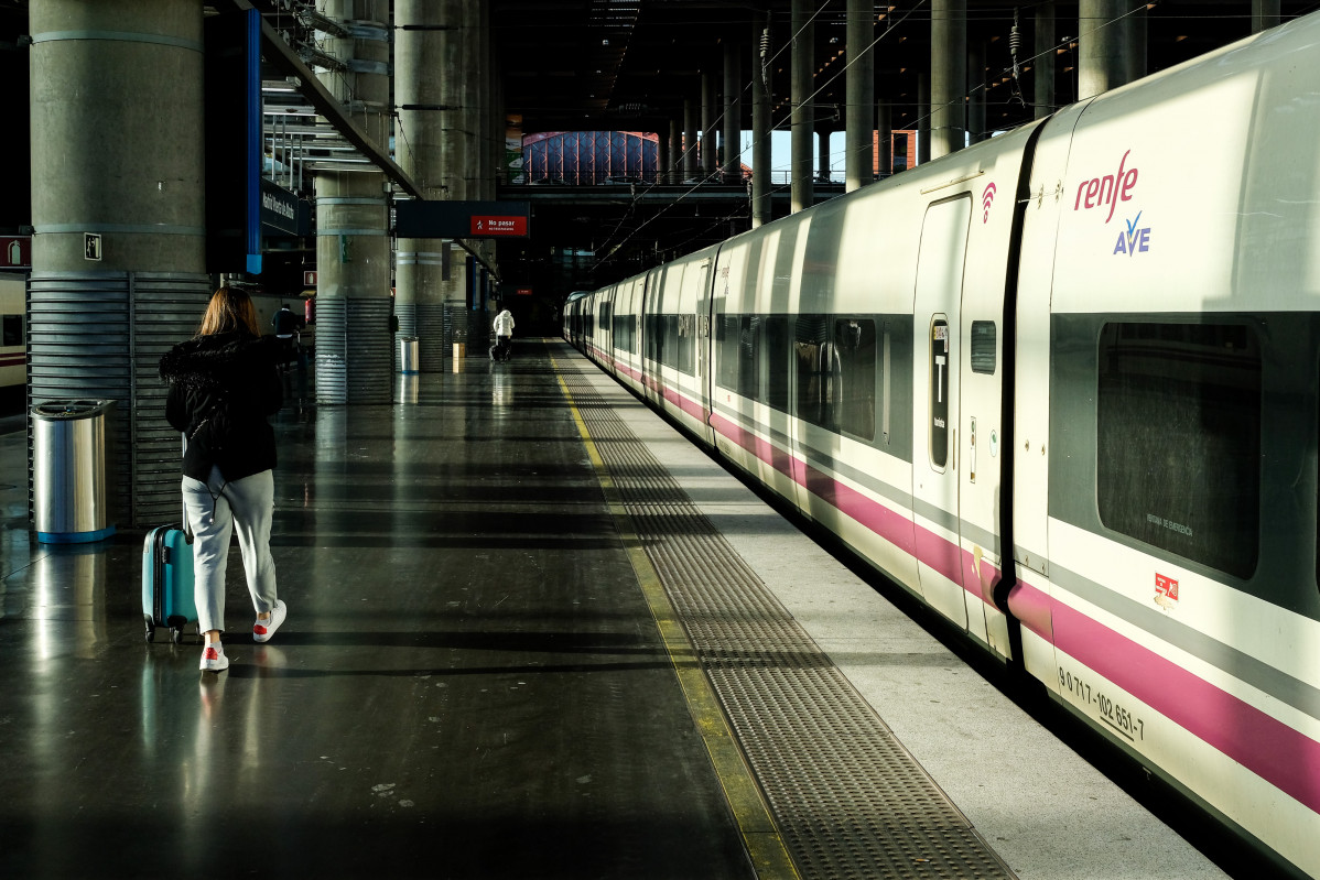 Una dona camina per l'andana al costat d'un tren d'AVE de Renfe estacionat a les vies de l'Estació d'Atocha, a Madrid (Espanya), a 6 de febrer de 2020.