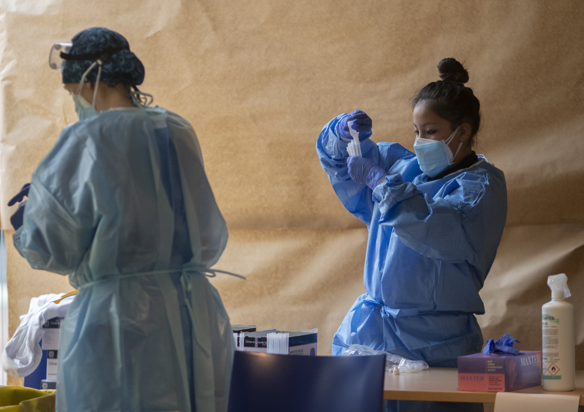Un treballador sanitari sosté una proveta en un dispositiu de cribratge massiu d'antígens organitzat per detectar positius per coronavirus en les instal·lacions de Centre Cultural Els Pins, en