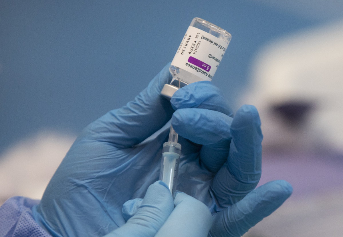 Una professional sanitària sosté una xeringa amb un vial de la vacuna contra la COVID-19 d'AstraZeneca