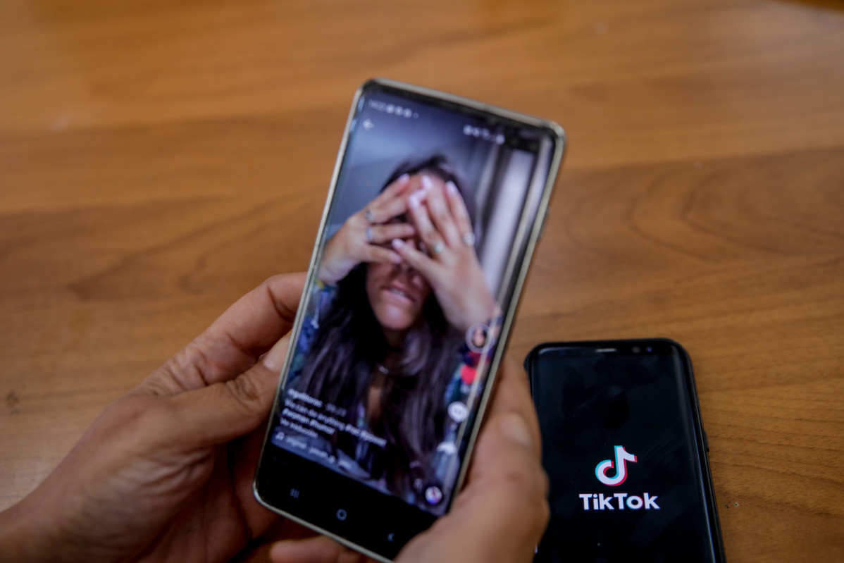 Una persona mira en super mòbil el vídeo d'una jove a la xarxa musical Tik Tok, a Madrid (Espanya).