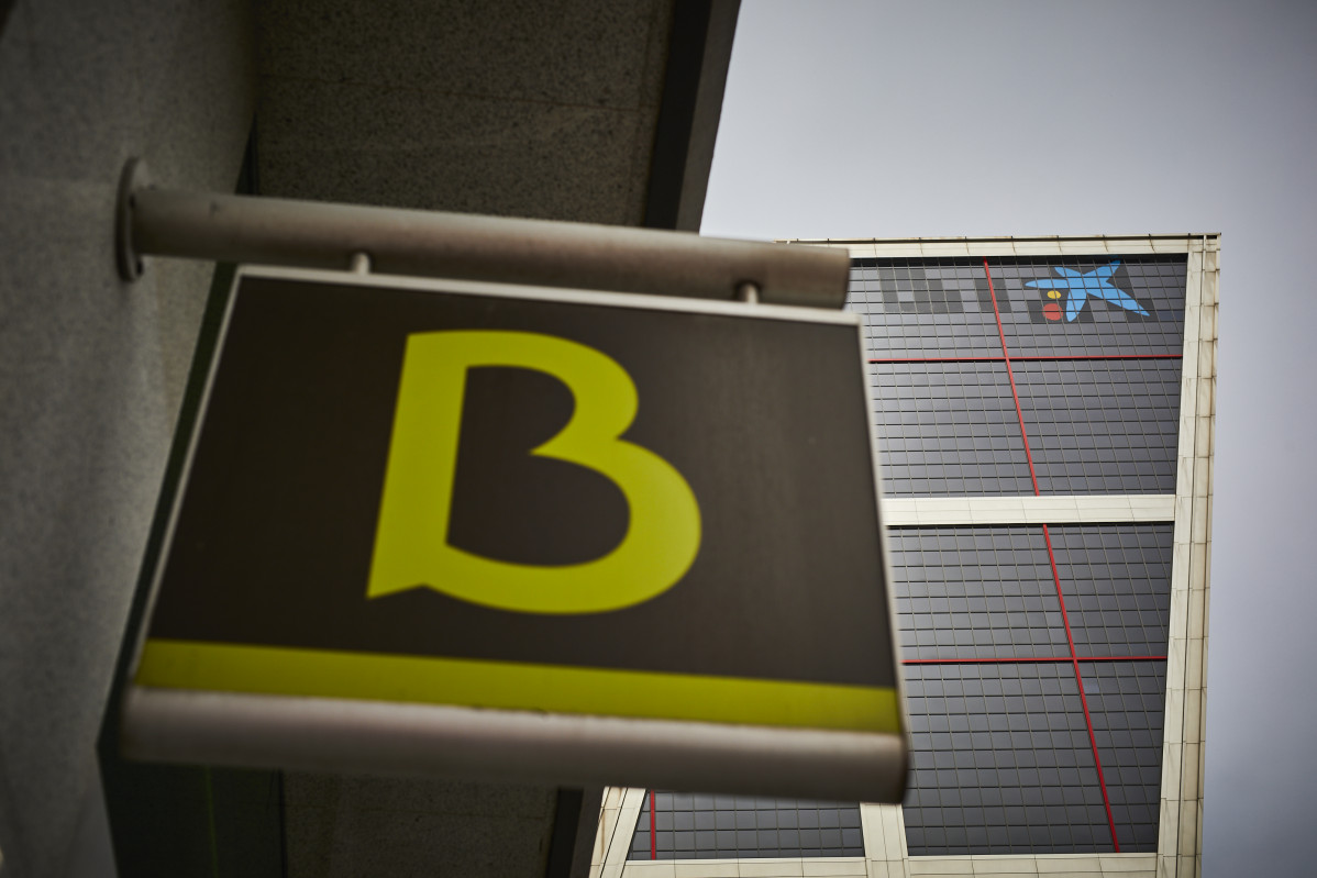 Un cartell amb el símbol de Bankia davant de el logo de Caixabank.