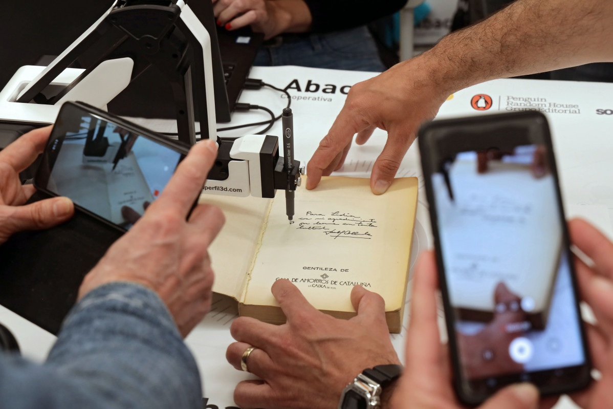 Signatura de llibres amb un braç robòtic a l'Espai Abacus